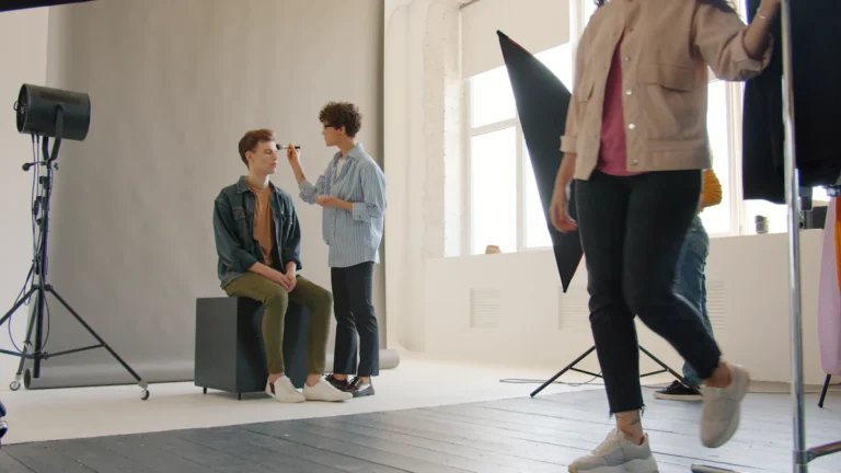 Students styling hair and makeup on set at a fashion photo shoot