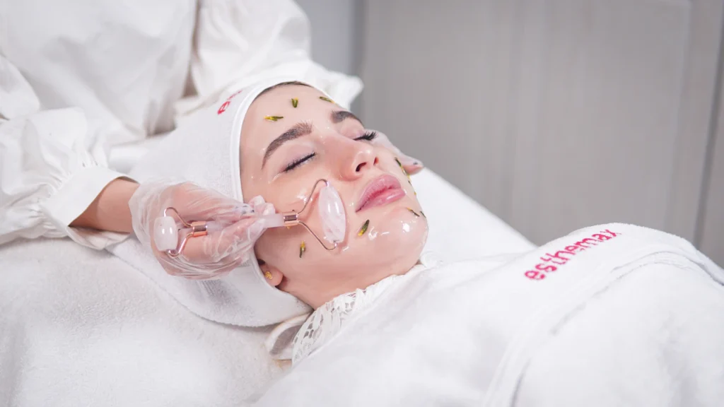 An esthetics student performing a facial treatment in a private treatment room