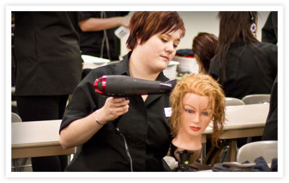 A cosmetology student practising on a mannequin head